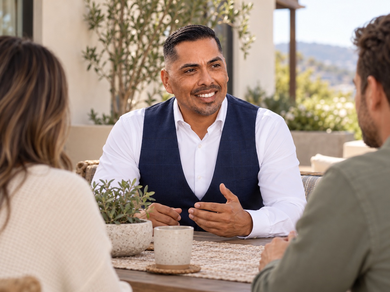 Eddie Guajardo speaking with homebuyers on a shaded home patio.